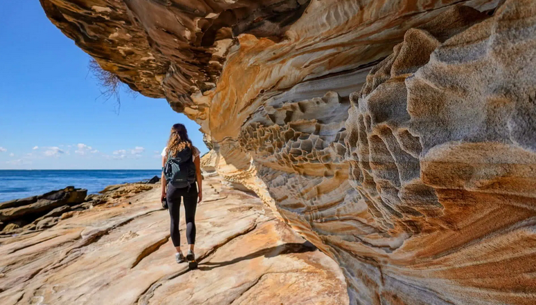 Walker overlooking dramatic coastal cliffs in Sardinia